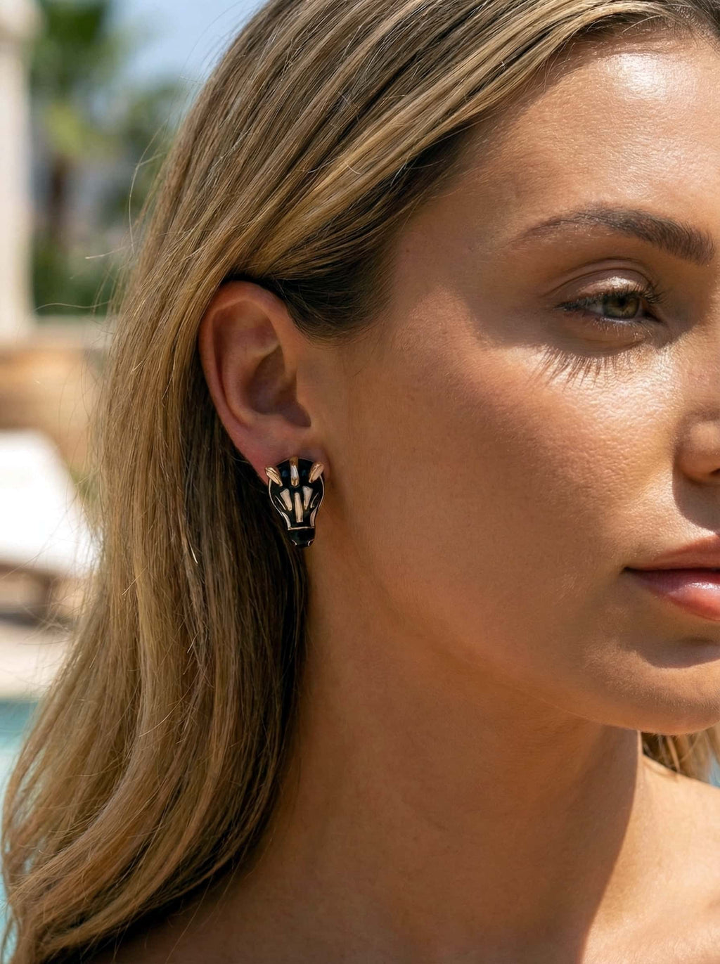Close-up of a woman wearing a zebra shaped earring outdoors.