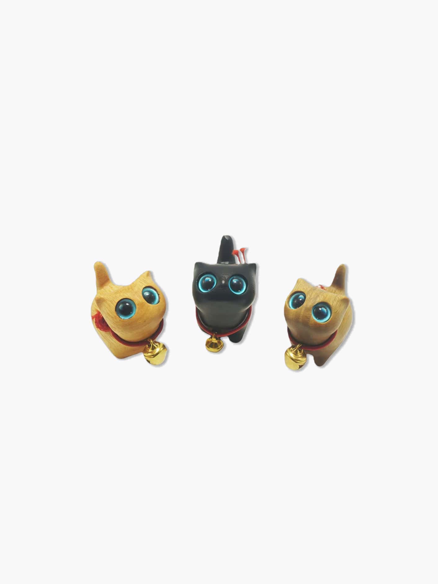 Three small wooden cat figurines with bell collars on a white background